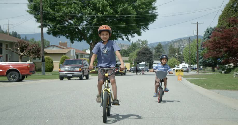 Two children ride their bicycles on the street