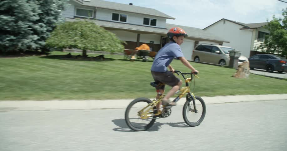 A child riding a bike down a road in a neighborhood