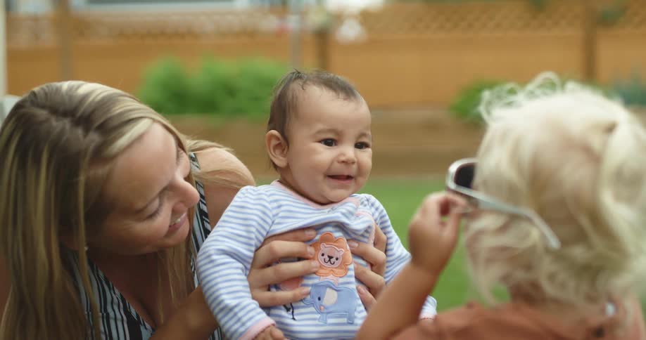 A mother and her children play in the yard