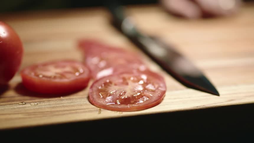 A person cut tomatoes with a knife