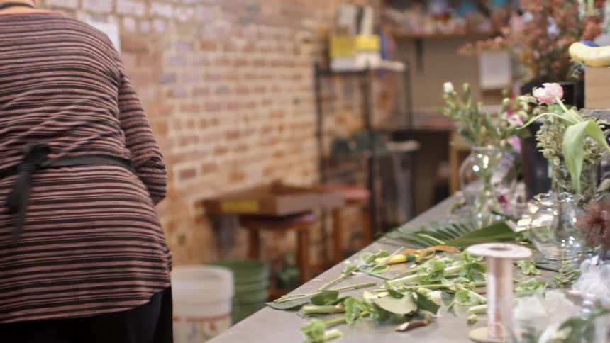 Florist gathering workable pieces from her table