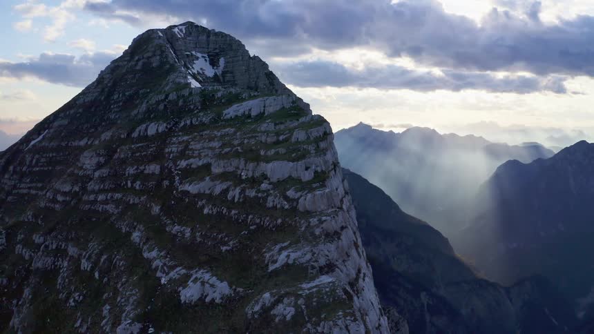 Aerial view of the snow covered steep cliffs on a mountain range at morning