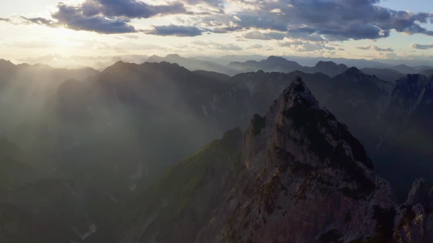 Rays of sunlight shining over a mountain range in the wilderness