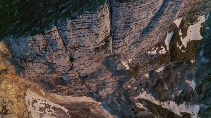 An aerial view of a canyon with snowy patches