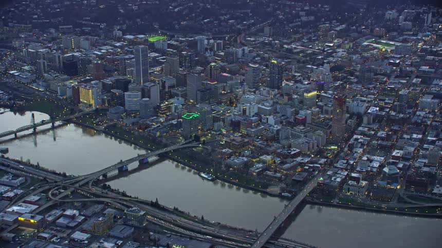 Medium wide aerial shot of downtown Portland Oregon and the Burnside Bridge, Morrison Bride and Hawthorne bridge spanning the Willamette River