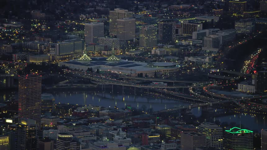 Aerial view of traffic flowing on a highway over a river crossing the city of Portland, Oregon at evening