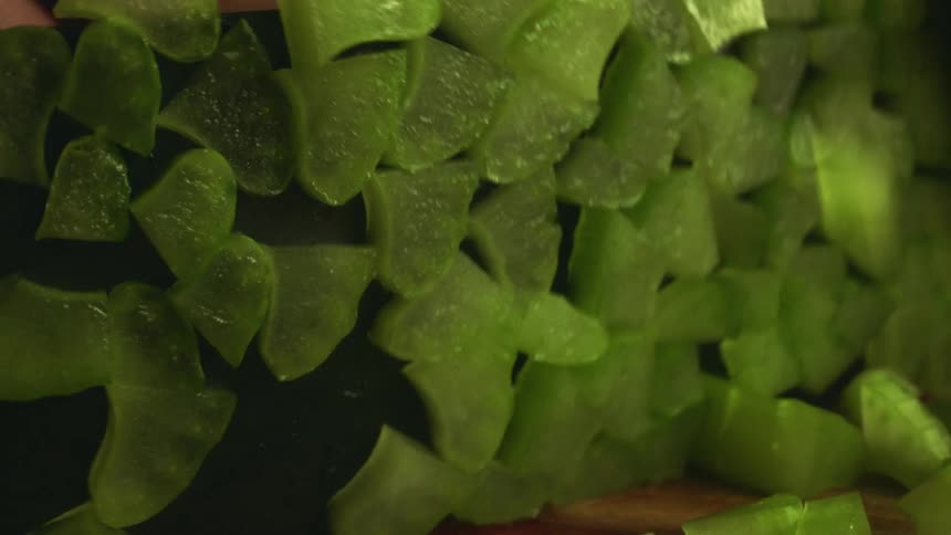 A person with a knife cutting vegetables on a cutting board
