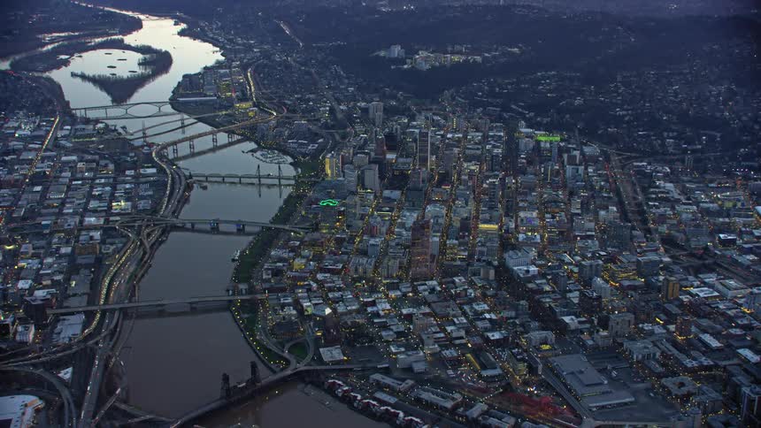 Wide shot aerial of blue hour light illuminating the downtown grid of Portland Oregon before night falls on the city landscape
