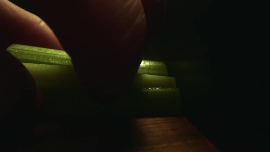 A person cutting celery on a cutting board