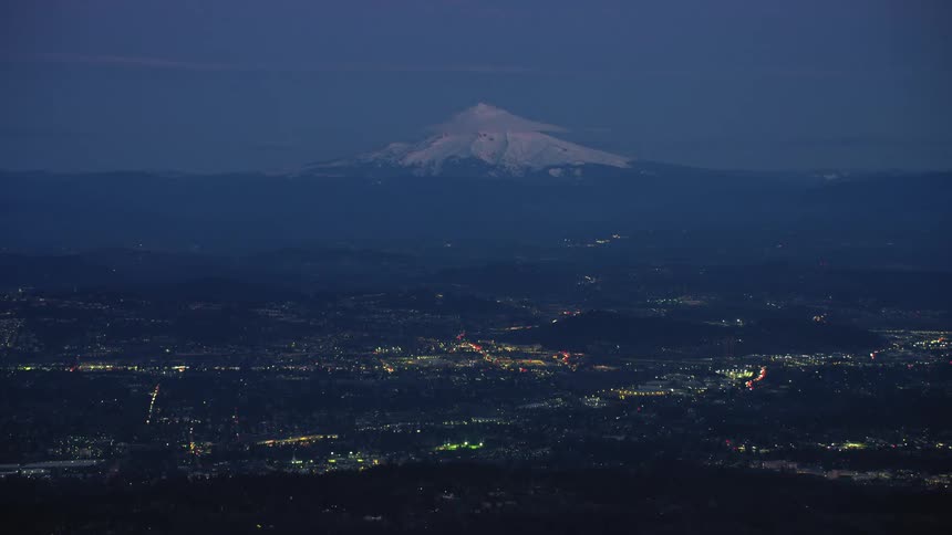 Mount Hood mountain on the horizon with Portland, Oregon in the foreground in this blue hour super wide shot