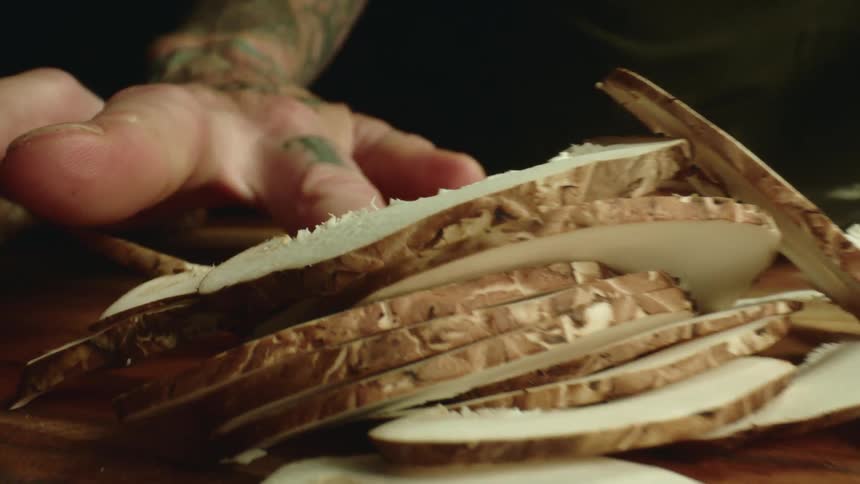 A man cutting food on a cutting board