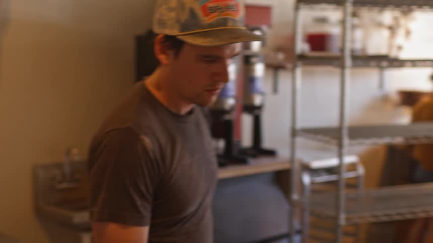 A man in a t-shirt sprays a table
