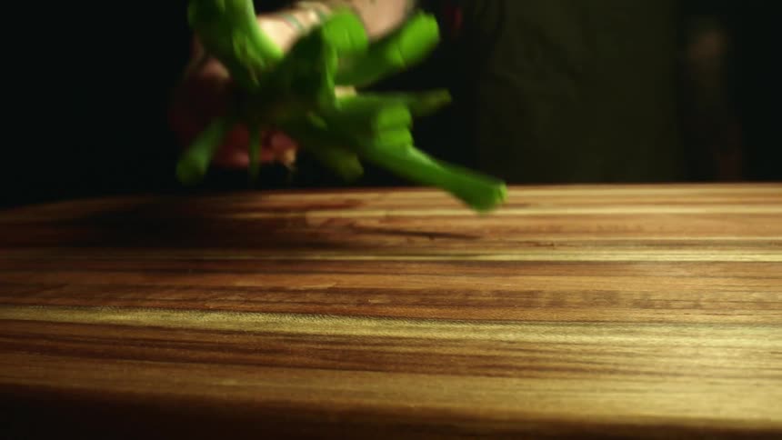 A person taking vegetables off a cutting board