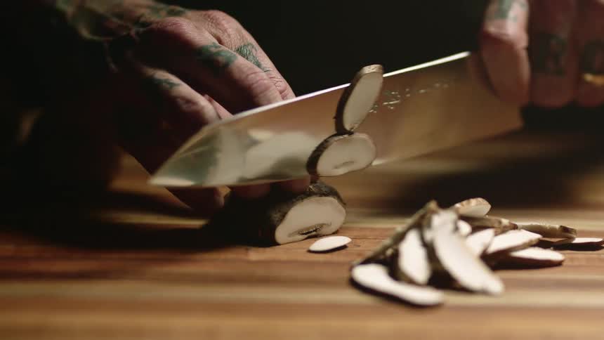 A man is cutting a potato with a knife