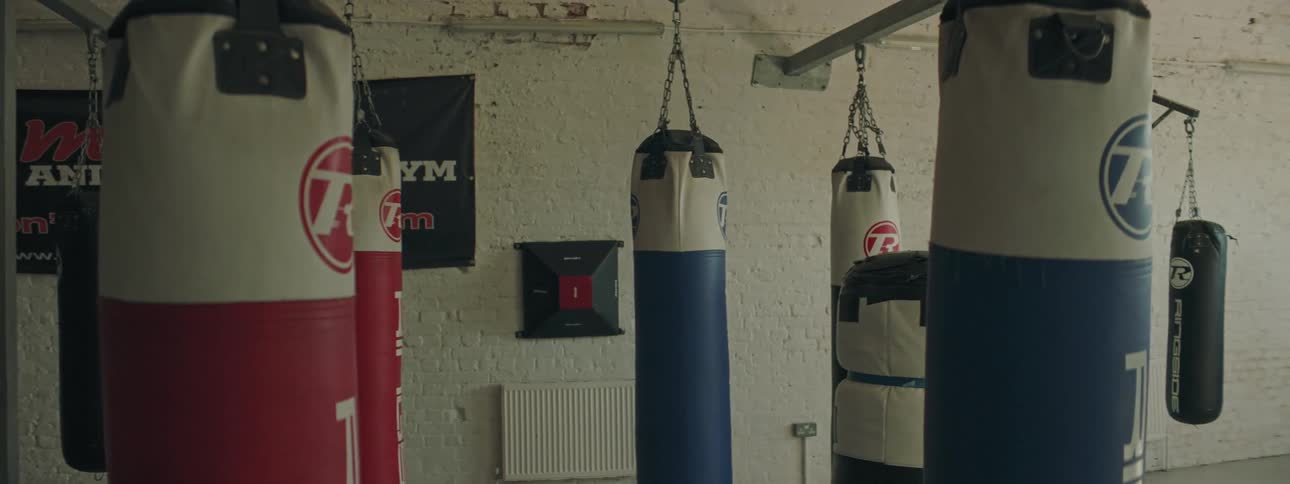 Several heavy bags hanging in an empty gym