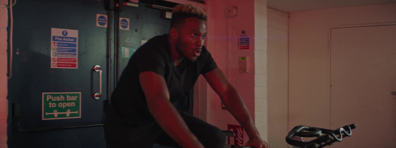 A man riding a stationary bicycle in a gym