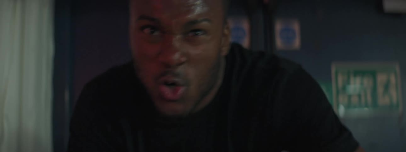 Strong muscular young man intensely training on a static bicycle in a gym