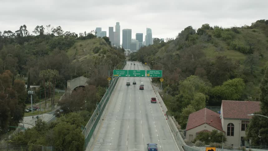 Cars driving on a highway with a city skyline in the distance