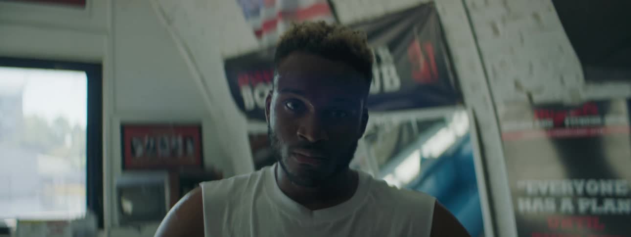 Young man looking at the camera standing on a room filled with posters