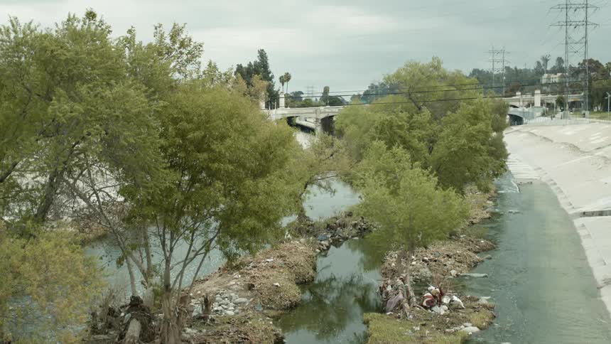 A river running along a street with people biking past