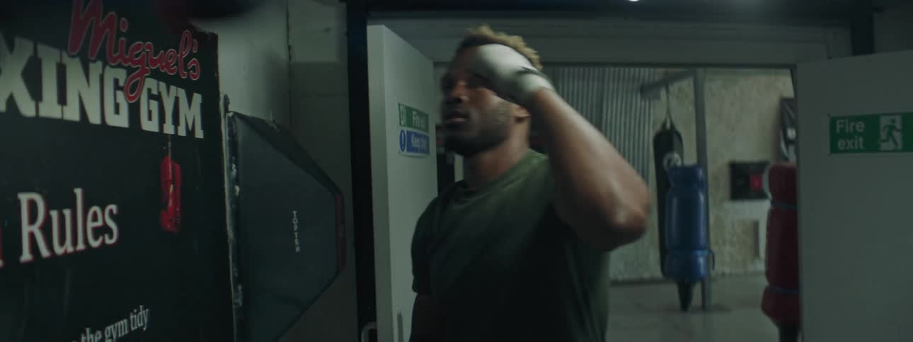A man is punching the speed bag in the gym