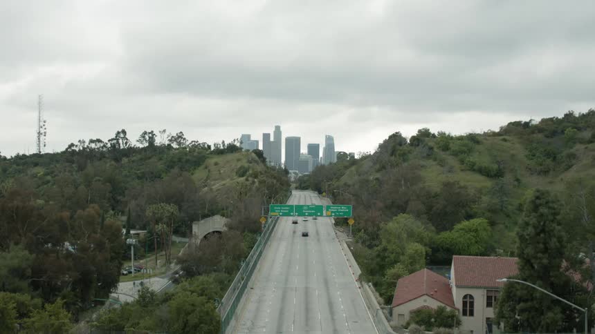 Vehicles driving down a highway heading to the citys downtown at daytime