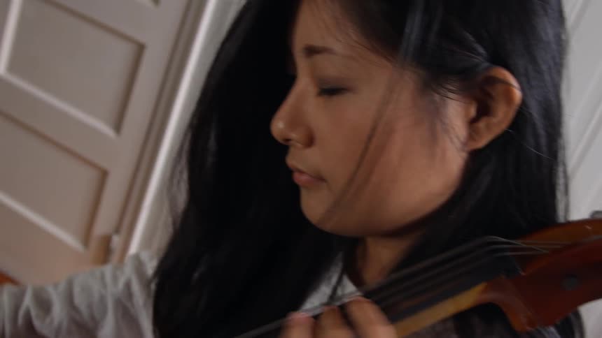 A woman with dark hair playing the cello