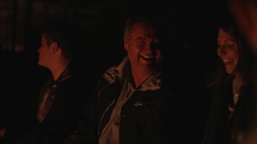 Group of people laughing around the campfire