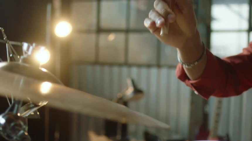 A drummer hitting a cymbal with a drumstick
