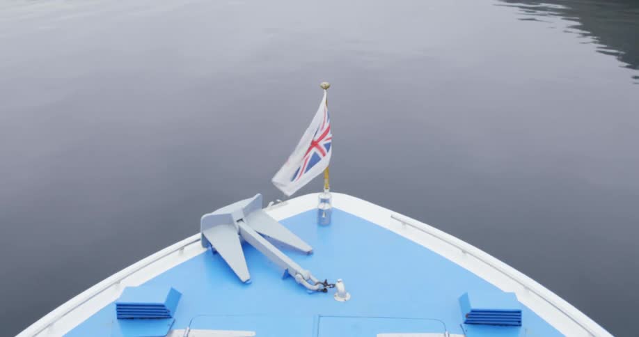 A shot of a front of a boat with a flag