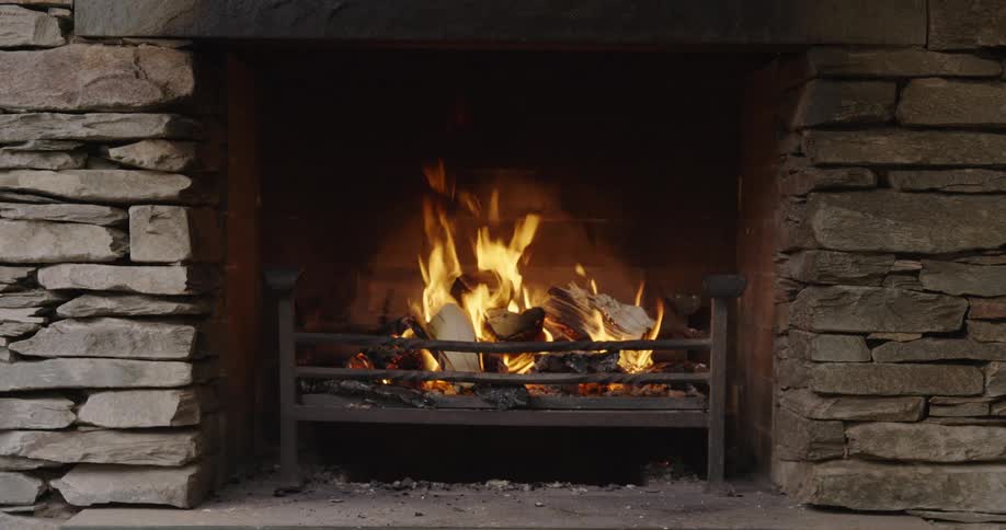 A wood fire burning in a stone fireplace