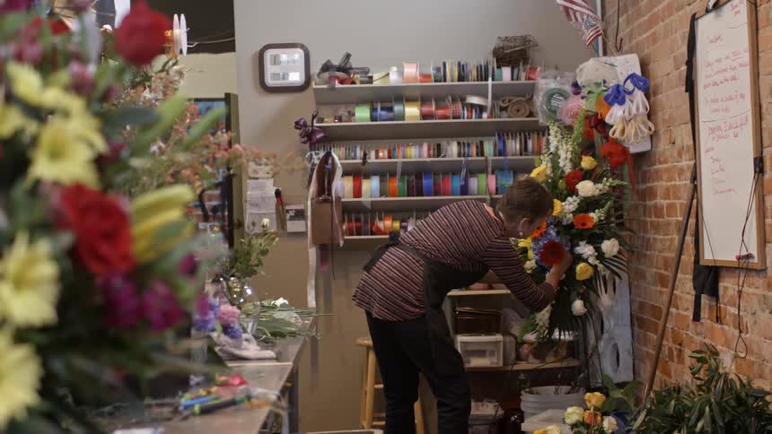 A woman working on a floral arrangement in a flower shop