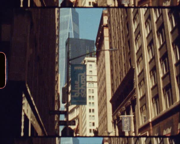 Pedestrians travel along the streets in the shadows of the towering skyscrapers of a metropolis on a sunny day