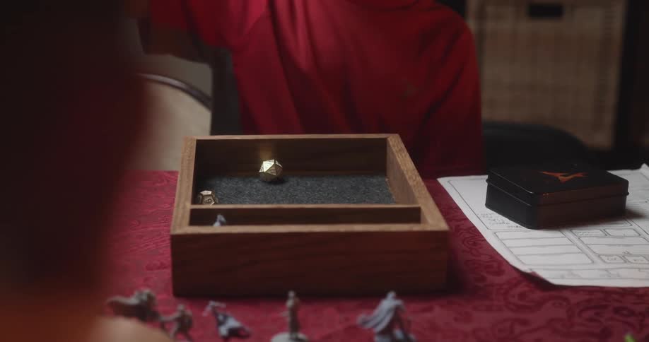 A child throwing the die in a box on a table