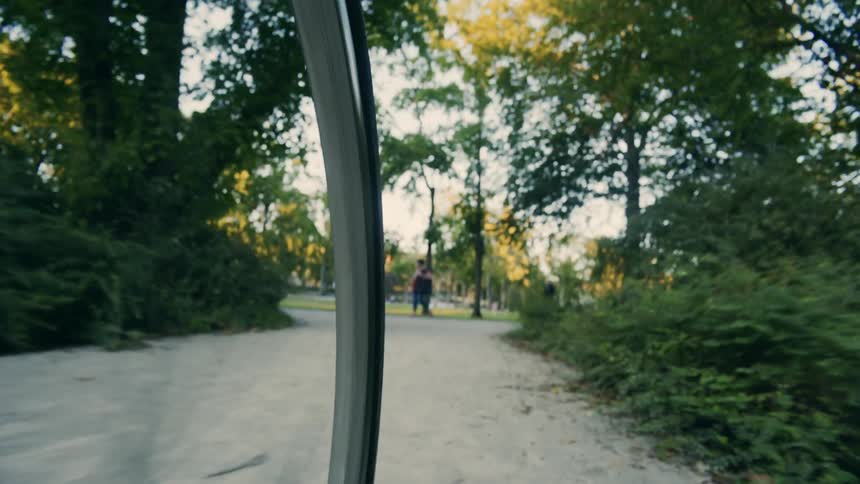 A person is biking through a park in spring