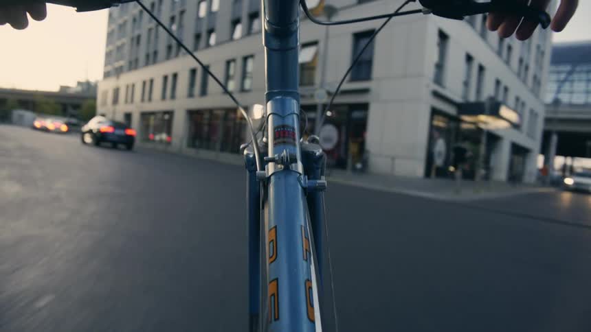 A cyclist rides a bicycle along the street of a metropolis during the day