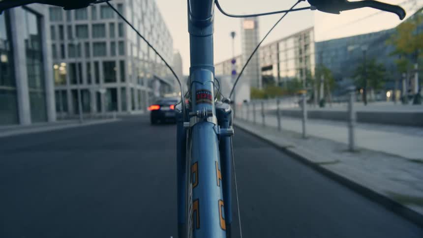 A bicyclist riding down a city street in the daytime