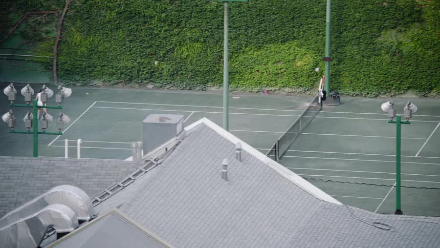 Women play doubles tennis at a sports club