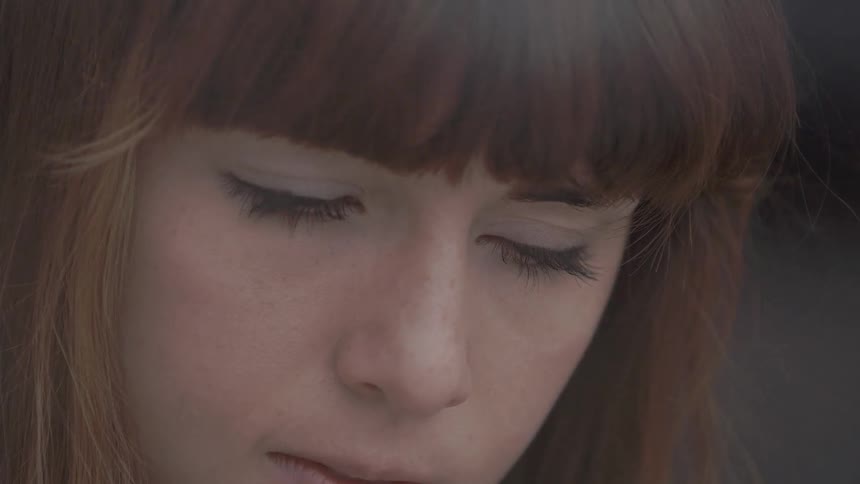 Close up of a woman looking down at something