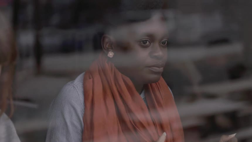 A  woman looks out of a window while sitting next to another woman