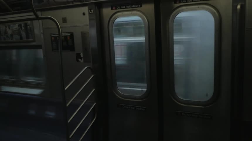 A train with train doors and windows seats and handrailing