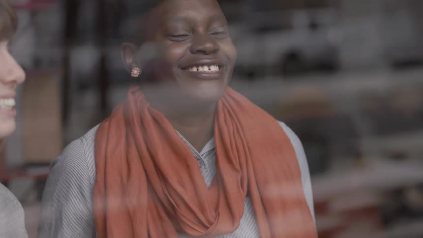 A woman talking and laughing at a table in a shop