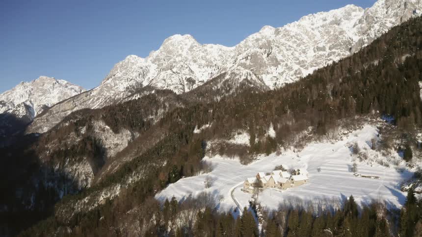 An aerial view of a small mountain village on a snowy winter day