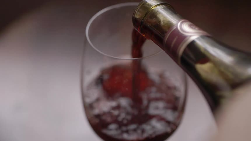 Wine is being poured into a glass