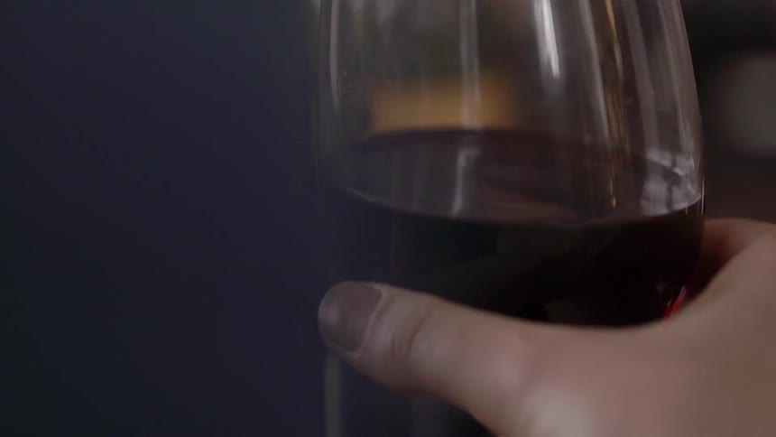 A person holds and swirls a wine glass