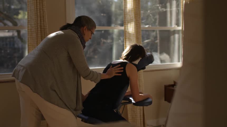 A woman is receiving a massage in a chair