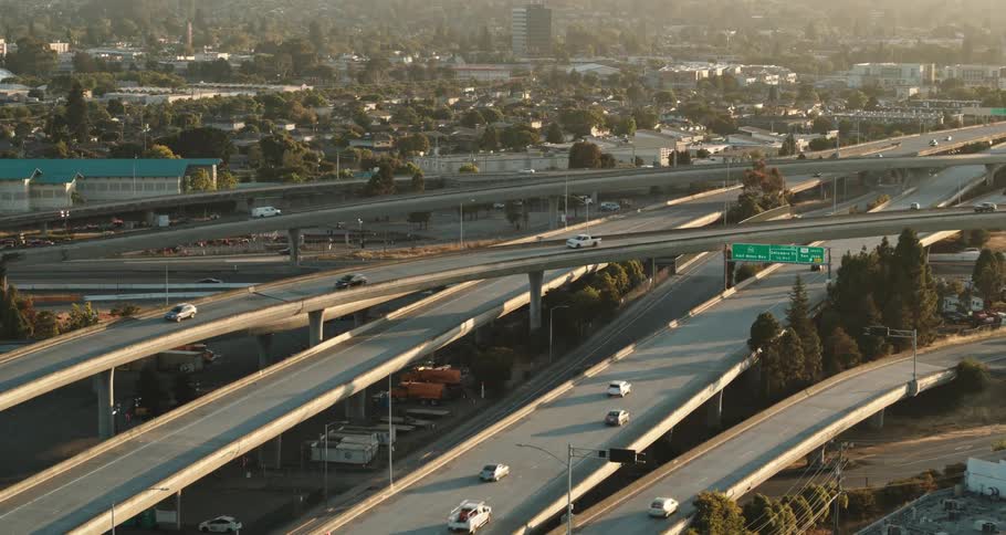 Busy highway with many cars and city buildings all around