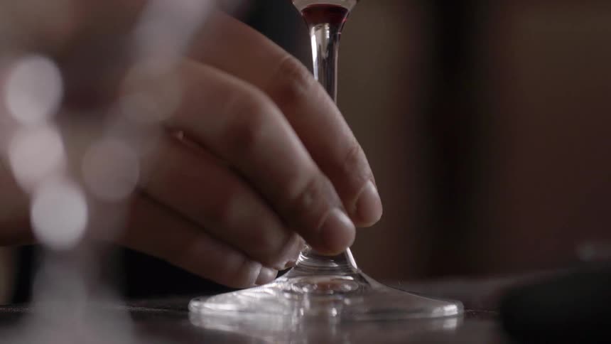 A glass is being slid across a table in a circle