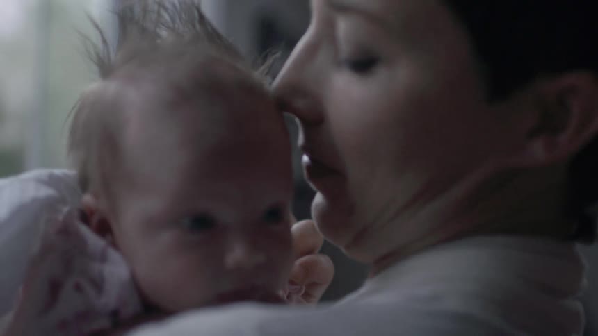 Close up of a woman looking at her baby in her arms