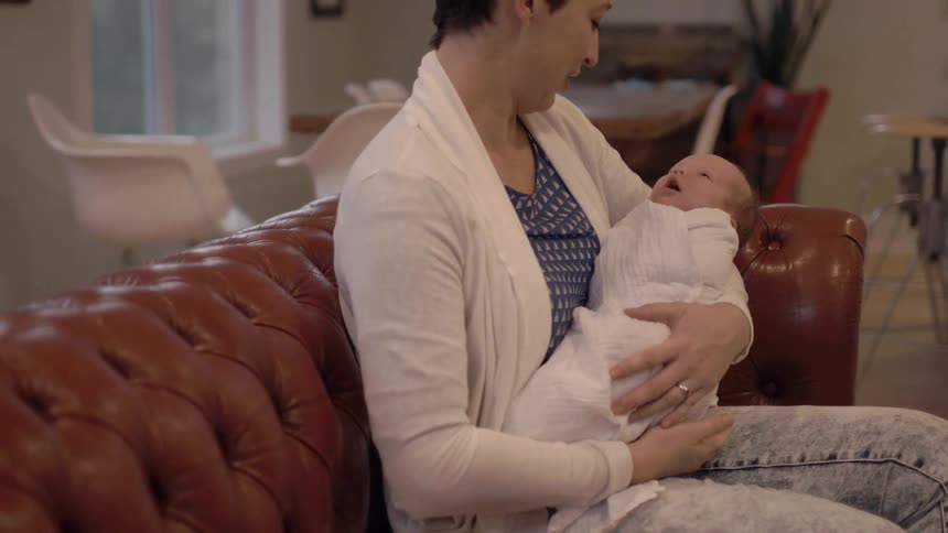 A woman is holding a baby in her arms